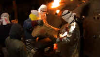 Ken Matsuzaki feeds charcoal into his climbing kiln